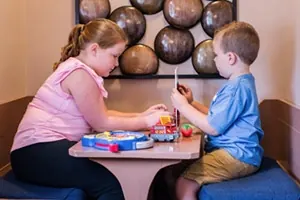 Two children playing at the children's table in the Sicher Family Dentistry waiting room.